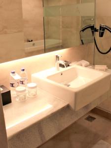 雅加达ASTON Pluit Hotel & Residence的浴室设有白色水槽和镜子