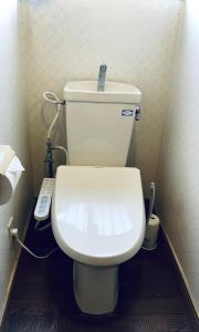 Kokubunji日久の宿的浴室内的白色卫生间,配有遥控器