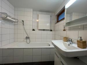 安特特泽Walensee Apartment, Lakeside Dream的白色的浴室设有浴缸和水槽。