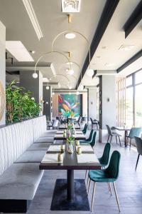 雷希察罗格酒店的长长的用餐室配有长桌子和绿色椅子