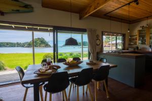 图图卡卡Absolute Beach front-Tutukaka Harbour的厨房以及带桌椅的用餐室。
