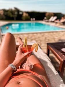 斯达林Beachfront Villa Victoras - With private beach的女人在游泳池前喝一杯