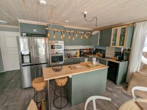 莱佩维尔塔#casakivicco的厨房配有带凳子的柜台和冰箱。