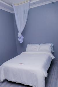 基苏木The VIP Luxury Lounge Hotel的卧室配有带窗帘的白色床