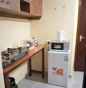 Fine Living - Busia的厨房配有炉灶、冰箱和微波炉