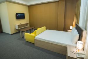巴库Ogguesto Hotel的酒店客房,配有床和黄色椅子