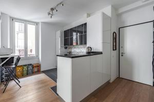 米兰Turro Cozy Apartment的厨房配有白色橱柜和台面