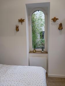 南特La laiterie de la Plume的一间卧室设有一张床和一个窗口