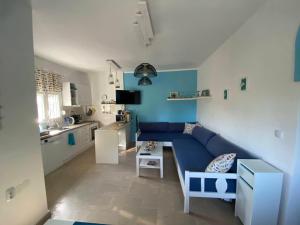艾斯普罗瓦塔Asprovalta SUNNY HOUSE的一间带蓝色沙发的客厅和一间厨房