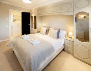 莱瑟姆-圣安妮The Masters by STAMP SA的卧室配有一张白色大床和两条毛巾