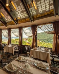布拉索夫贝尔福德雷尔酒店的餐厅设有桌椅和大窗户。