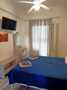 帕罗奇亚玛丽莎酒店的一间卧室配有一张蓝色的床和吊扇