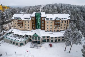 SarıkamısSARPİNO MOUNTAİN HOTEL的雪中建筑物的空中景观