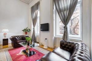 布达佩斯Royale Apartment的客厅配有皮革家具和窗户