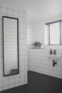 利兹Blackett Street Bunkhouse的白色瓷砖浴室设有镜子和水槽