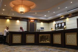 利雅德Carawan Al Khaleej Hotel Olaya的两人站在酒店大堂的酒吧