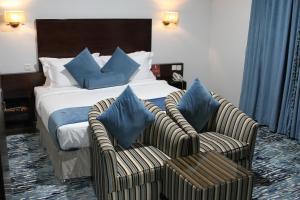 利雅德Carawan Al Khaleej Hotel Olaya的酒店客房,配有一张床和两把椅子