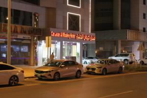 利雅德Carawan Al Khaleej Hotel Olaya的三个汽车晚上停在停车场