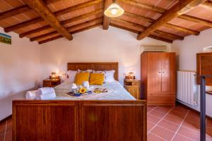 Santa Maria AlbianoAl Giardino degli Ulivi的一间带一张大床的卧室,位于一个拥有木制天花板的房间