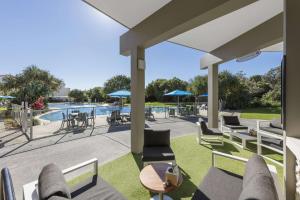 马库拉马库拉海滩华美达酒店的一个带桌椅的庭院和一个游泳池
