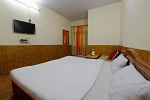 ShamshiOYO Hotel Sunbeam的卧室配有一张白色大床和一台平面电视。