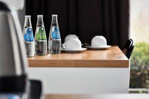 格但斯克雷比赫瓦Sleepinn Gdansk Airport的一张木桌,上面有四瓶和盘子