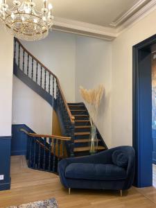 鲁贝La Villa Barbieux的客厅设有蓝色的沙发和楼梯。