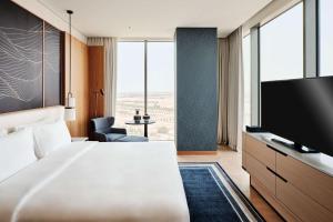 科威特Grand Hyatt Kuwait的配有一张床和一台平面电视的酒店客房