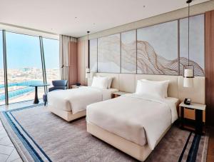 科威特Grand Hyatt Kuwait的酒店客房设有两张床和大窗户。