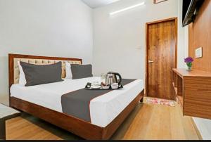 德拉敦Hotel StudioZ Sahastradhara的一间卧室配有一张床,上面放着一个食物托盘