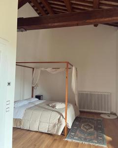 Pietrafitta阿巴其亚赛特弗拉迪弗拉特利斯农家乐的一间卧室配有一张天蓬床和地毯。