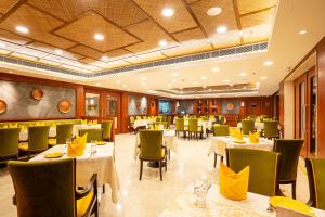 杜尔加布尔Fortune Park Pushpanjali, Durgapur - Member ITC's Hotel Group的一间在房间内配有桌椅的餐厅