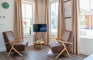 OttolandFamilie Resort Molenwaard的客厅配有两把椅子和电视