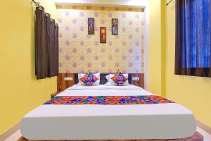 乌代浦FabHotel Lotus的一间卧室配有一张带蓝色窗帘的大床