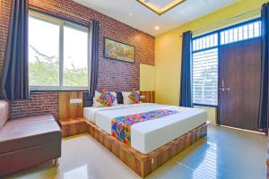 乌代浦FabHotel Lotus的一间卧室设有一张床和砖墙