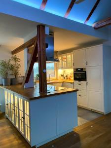 柏林Green Caroline的一间设有白色橱柜和蓝色天花板的大厨房