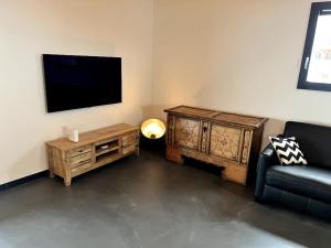 博尔蒂根Chalet Charbon的客厅配有电视、沙发和桌子