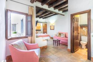 布斯奇斯塔Hotel Apartamento Nueva Alcazaba的客厅配有粉色椅子和沙发