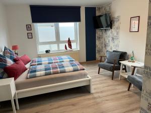 纽哈灵吉塞尔Pension Blaue Nordseewelle的一间卧室设有一张床、一个窗口和一把椅子
