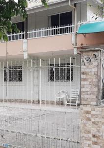 伊塔佩马Casas de Aluguel da Lulu的房屋前的围栏,有两把椅子