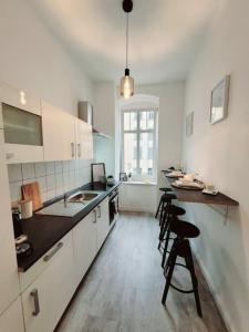 德累斯顿Daheim in Dresden的厨房配有白色橱柜和黑色台面