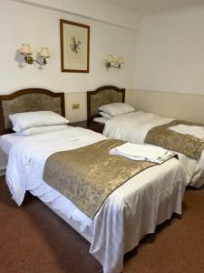 绍斯韦尔撒拉逊首领酒店的酒店客房,配有两张带白色床单的床