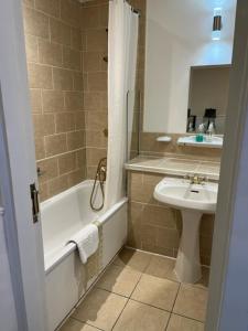 绍斯韦尔撒拉逊首领酒店的一间带水槽、浴缸和卫生间的浴室