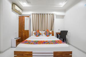 浦那FabHotel Omkar Executive的一间卧室配有一张大床和一张书桌