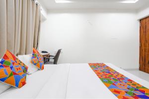 浦那FabHotel Omkar Executive的一间卧室配有一张带彩色毯子的床