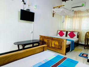 阿努拉德普勒Rich Resort & Restaurant的客房设有1张床、1张桌子和1台电视。