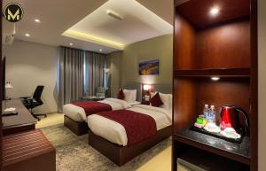 马斯喀特Muscat Express Hotel的酒店客房配有两张床和一张书桌