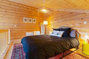LalayeLe chalet des bois的卧室配有木墙内的一张床