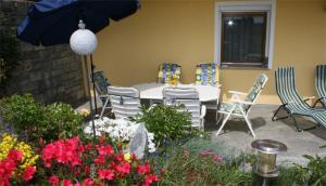 韦格沙伊德Ferienwohnung Tahedl的庭院配有桌椅和遮阳伞。