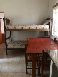 阿肖海Don Pocho的客房设有桌子、高架床、桌子和长凳。